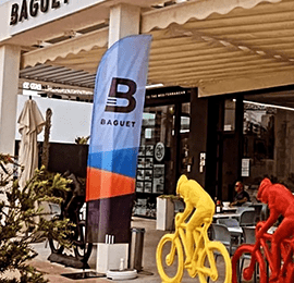 Bedrukte beachvlag in de inkomhal van het Baguet Bicycle Center in Spanje, ideaal voor indoor visibiliteit